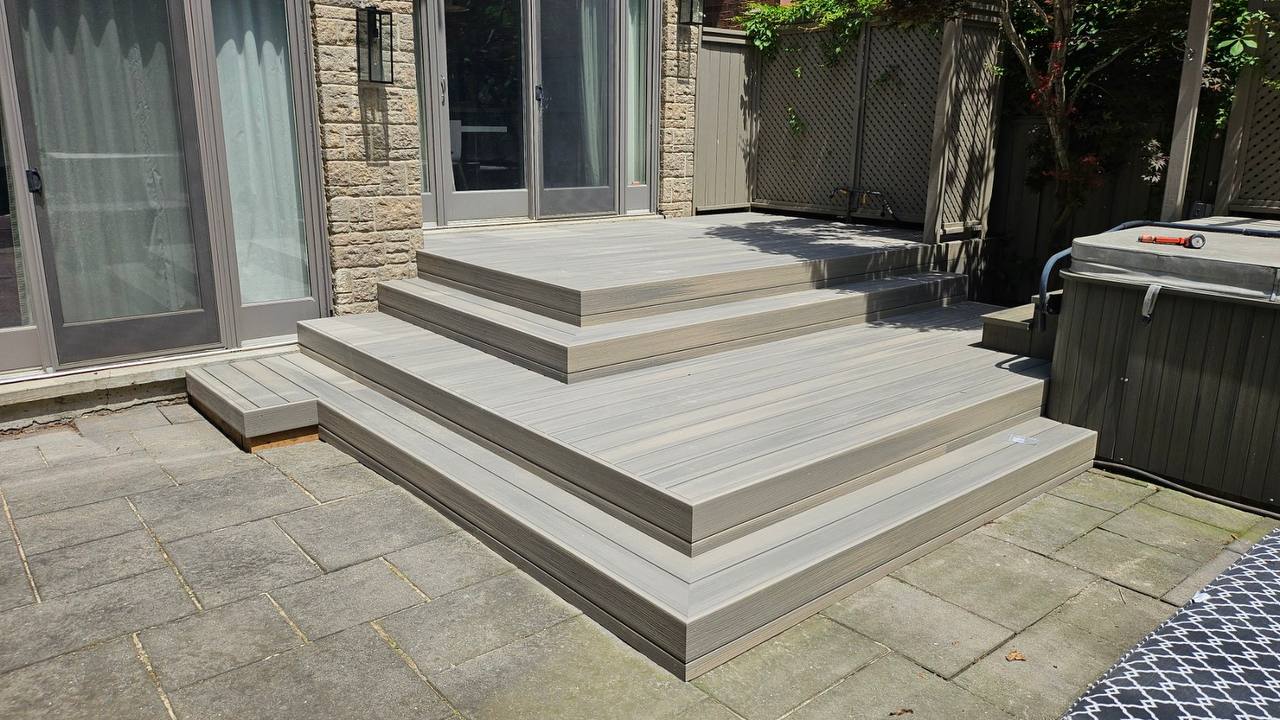 Terrasse multiniveau en composite gris avec spa dans une cour de Candiac